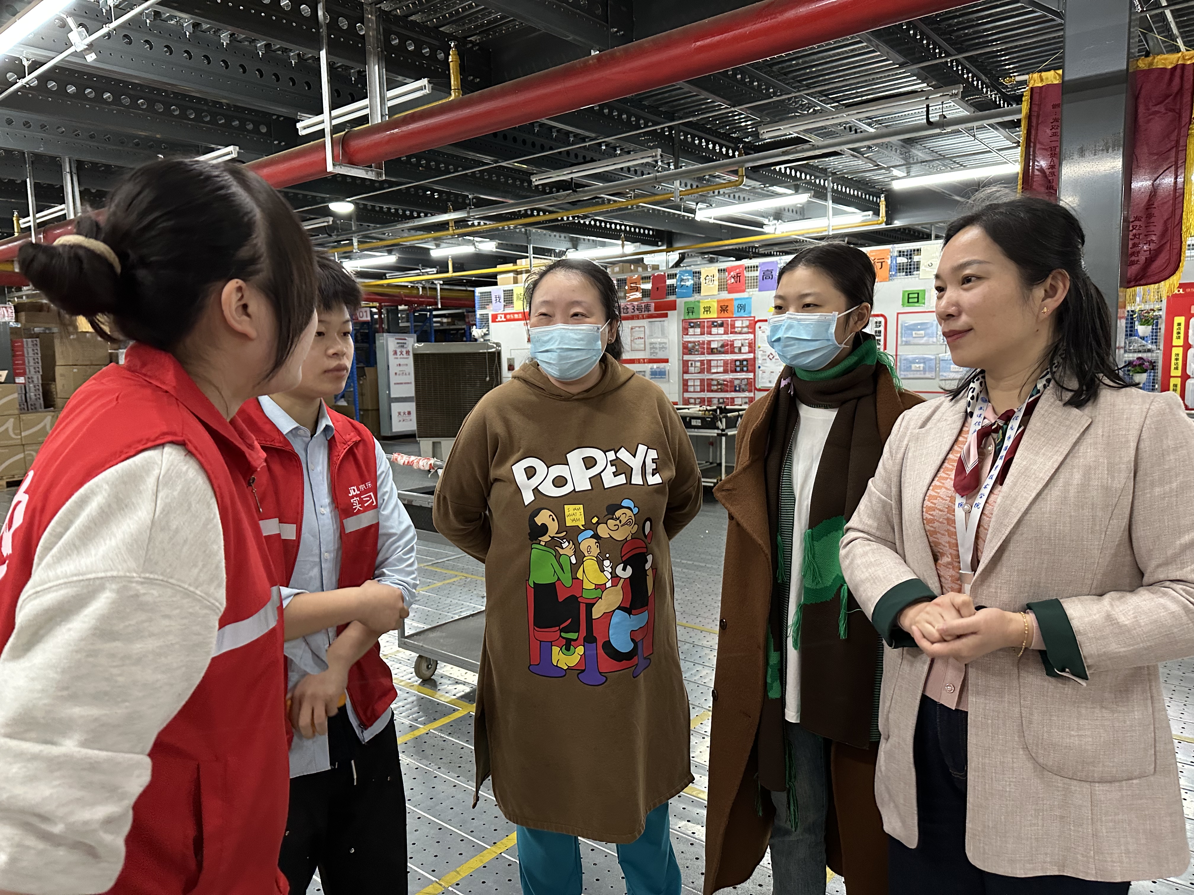 圖4-2 商學(xué)院院長李靜榮、副院長陳萍在倉里指導(dǎo)學(xué)生，與學(xué)生親切交流